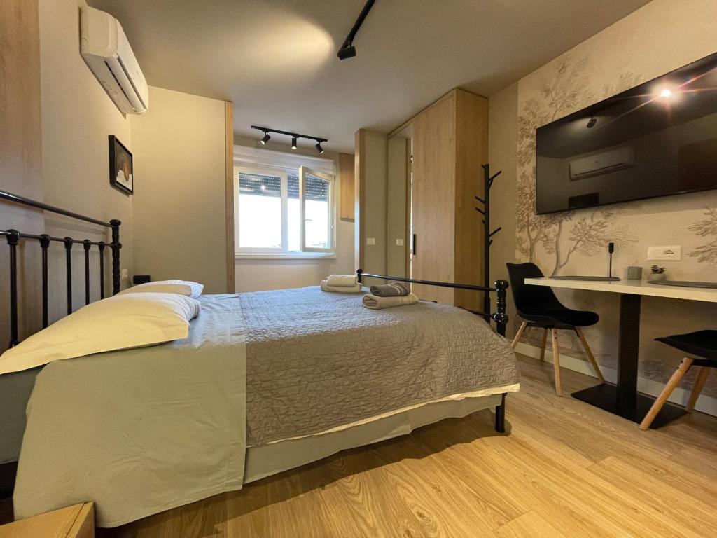 a bedroom with a bed and a desk in it at Piazza Downtown Cozy Studio in Tirana