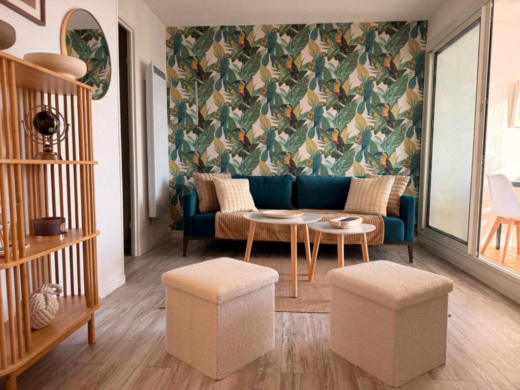 un soggiorno con un divano blu e un tavolo di Le Barcarelle a Le Barcarès