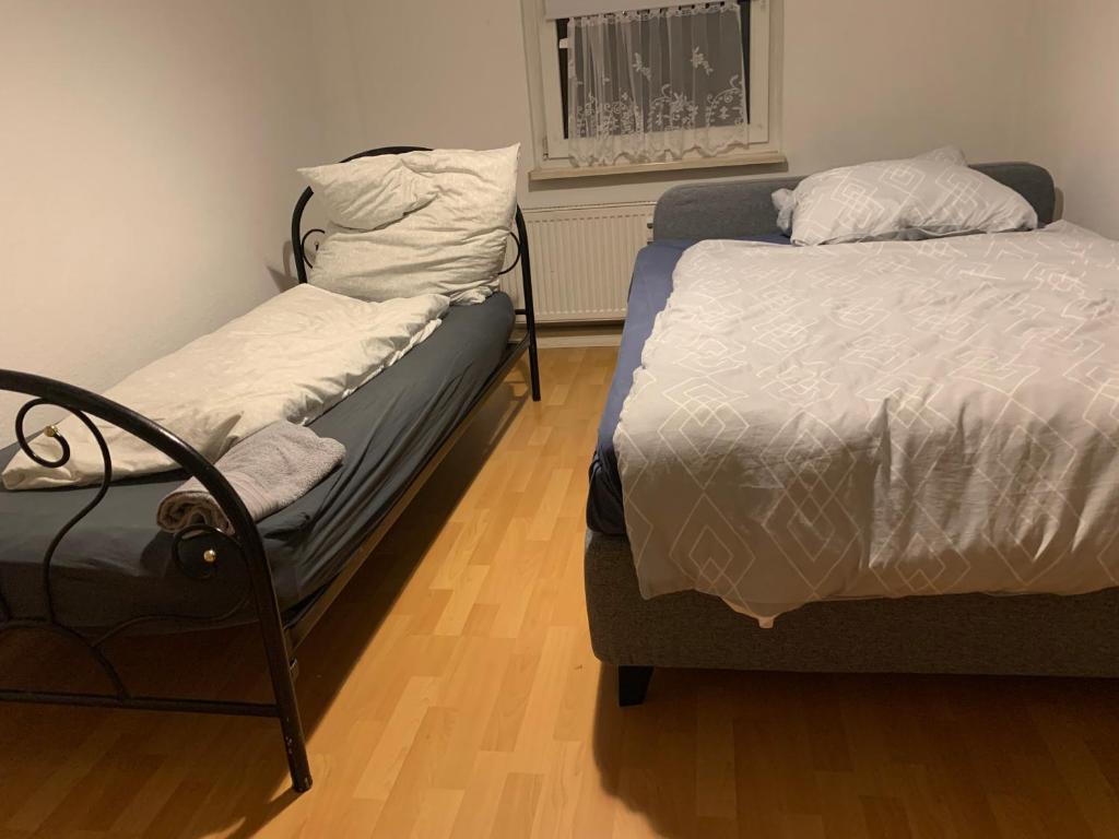 Un dormitorio con dos camas y una silla dentro. en Geräumige Wohnung Nähe HBF, en Eisenach