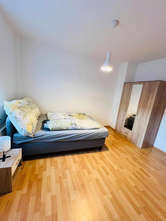 een woonkamer met een bed en een houten vloer bij Geräumige Wohnung Nähe HBF in Eisenach