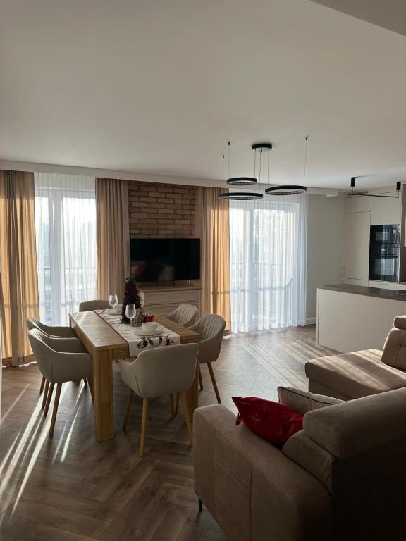 een woonkamer met een tafel en een bank bij Panorama 79 in Nowy Targ