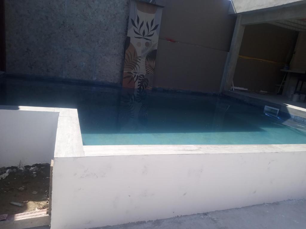 Casa na Prainha de Mambucaba في باراتي: مسبح بمياه خضراء في مبنى