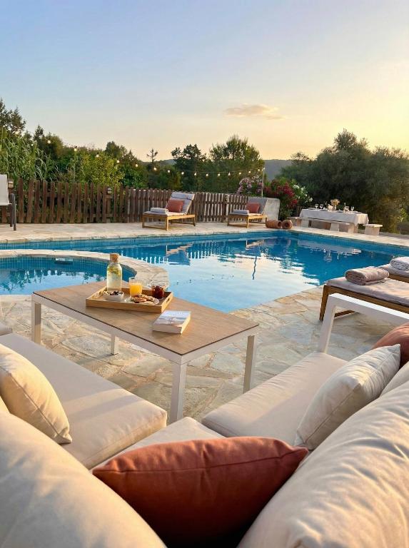 a pool with lounge chairs and a table next to it at Villa Can Mestreso Suite Ibiza in Sant Joan de Labritja