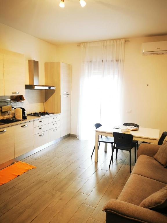 Rossi apartment في Mentana: غرفة معيشة بها طاولة ومطبخ