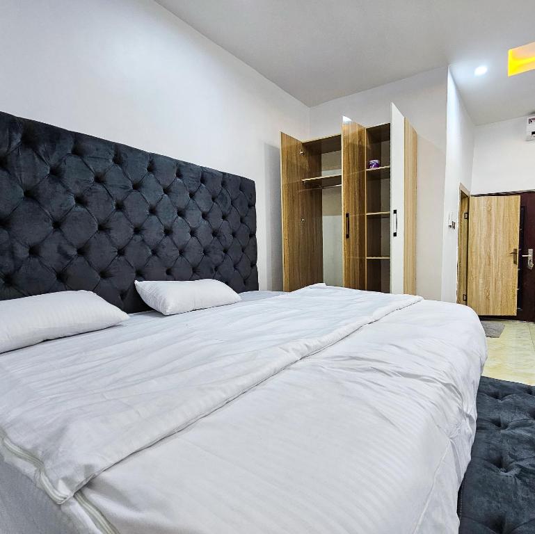 a bedroom with a large white bed with a black headboard at 3-Bedroom fully serviced terrace in Orchid, Lekki Sig4 in Lekki