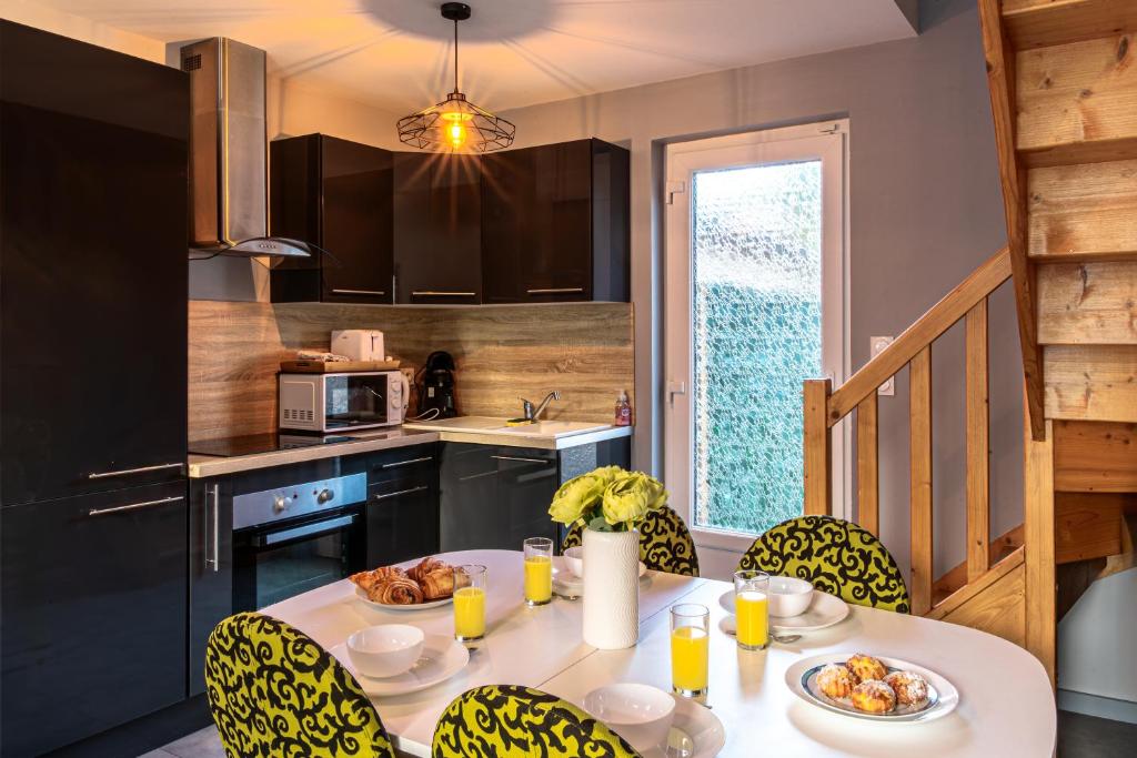 a kitchen with a table and chairs with food on it at La maison de la mer in Criel-sur-Mer