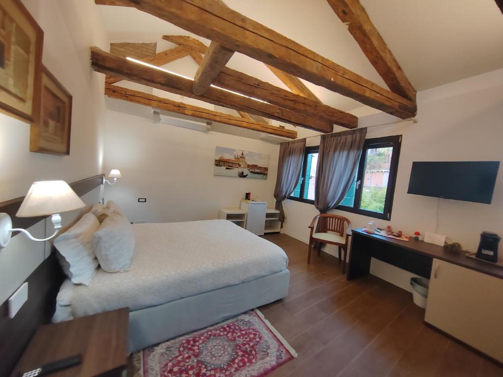 a bedroom with a bed and a desk in a room at Casa sulla Laguna CASTELLO in Venice