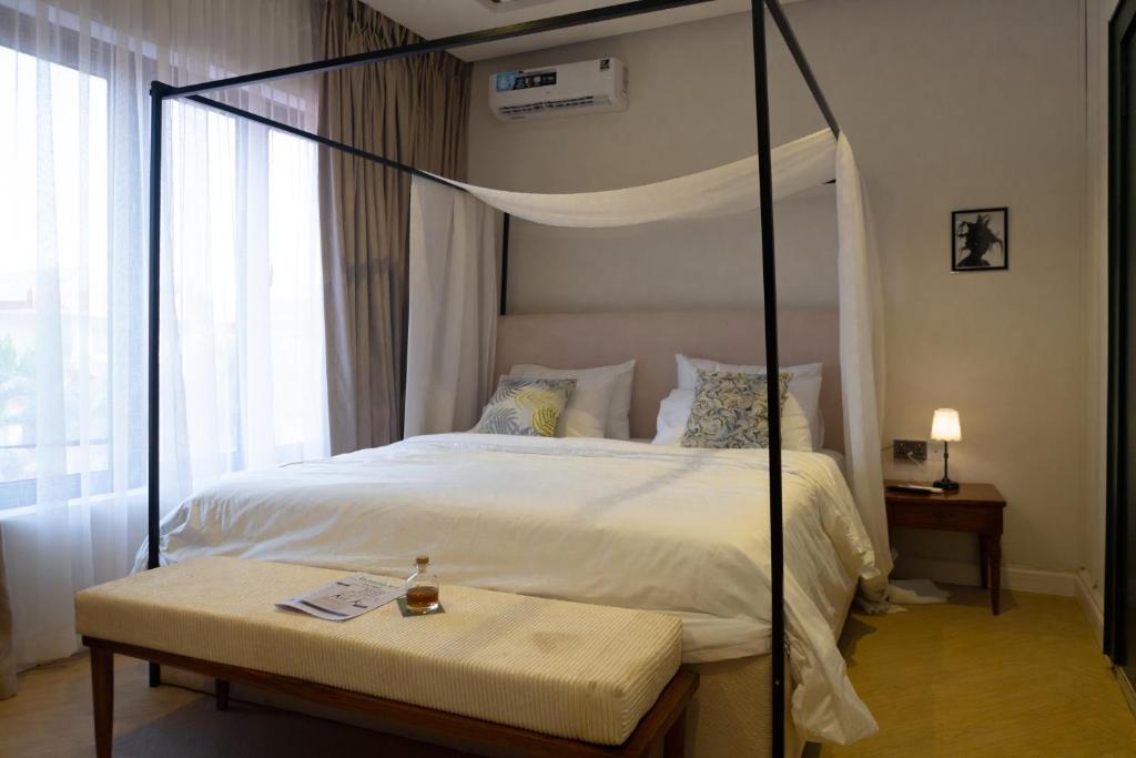 a bedroom with a canopy bed and a table with a candle at The Libreville in Abuja
