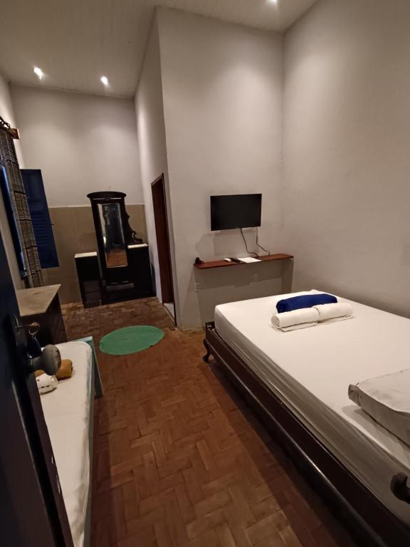 安达拉伊Pousada e Hostel Andarai的房间里有一张床和一台电视的卧室