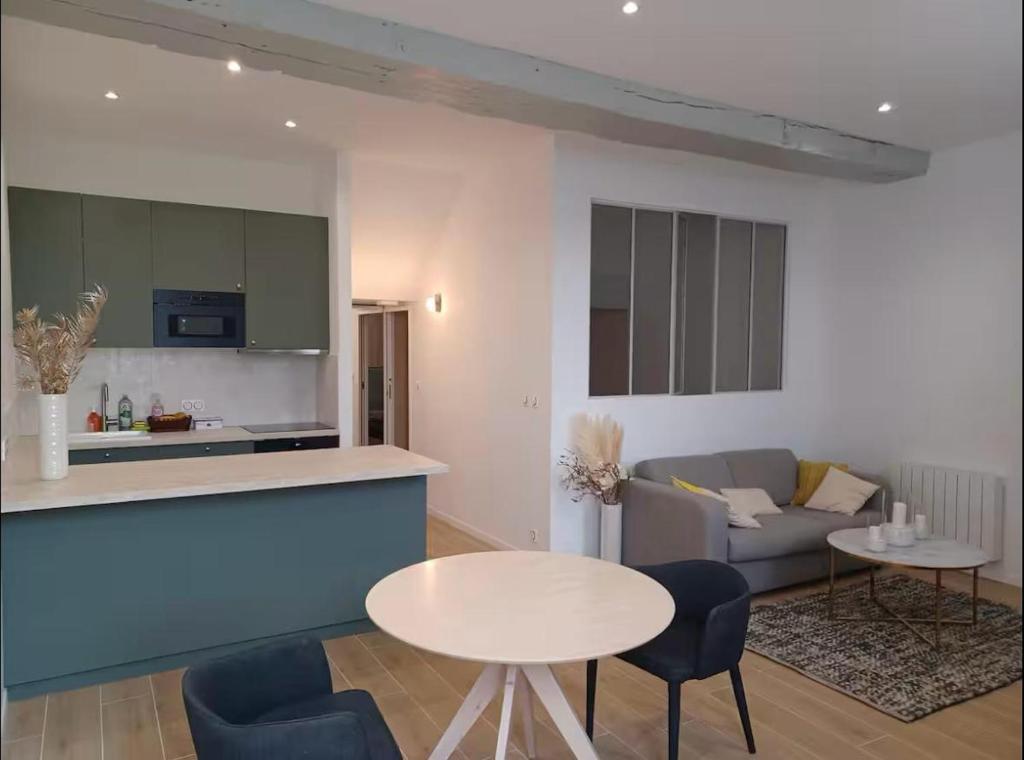 a kitchen and living room with a table and a couch at Superbe 2 pièces refait à neuf idéalement situé in Meung-sur-Loire