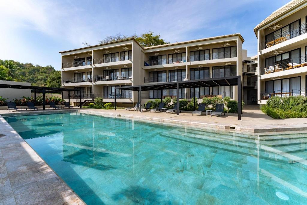 an image of a swimming pool in front of a building at 3077 - Solana B203 in Santa Cruz Huatulco