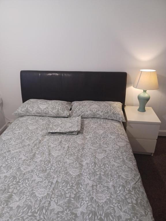 a bedroom with a bed with a black headboard at Christian Guest House 1 in Luton