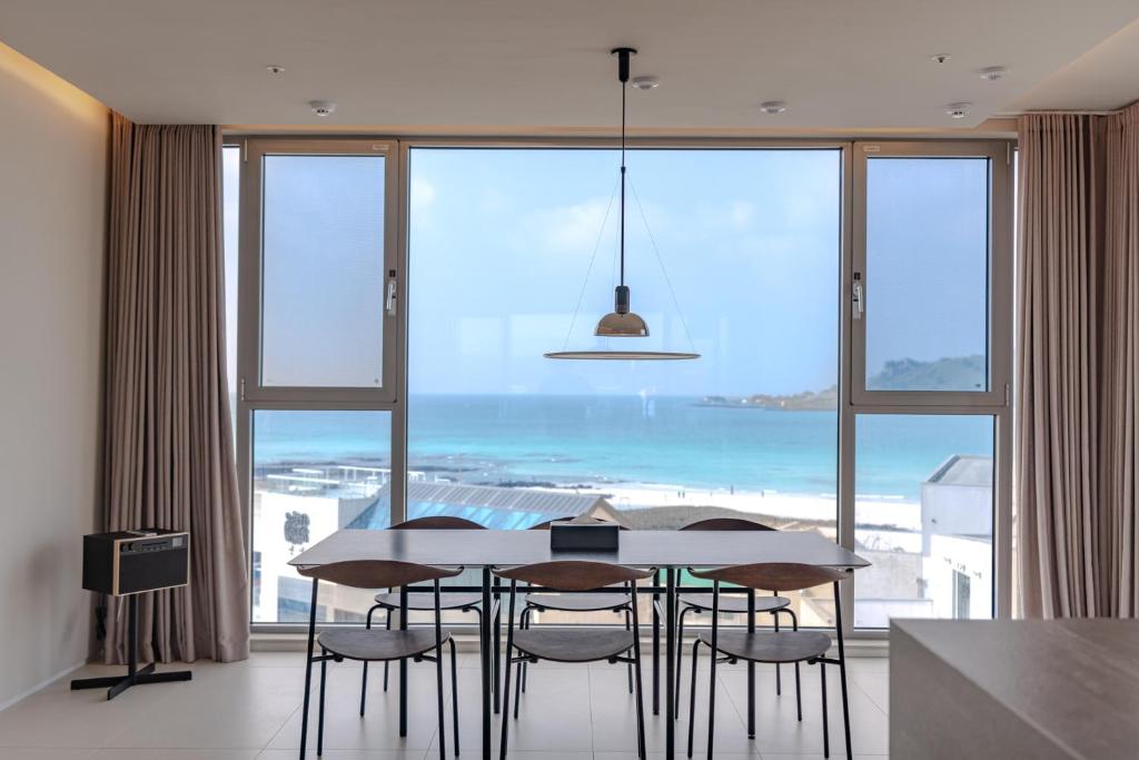 콘스트호텔 في Hyŏpchae-ri: غرفة طعام مع طاولة وكراسي ونافذة كبيرة