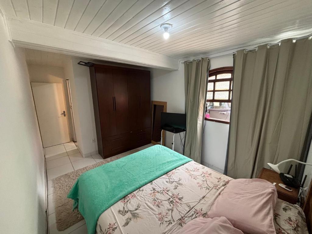 een slaapkamer met een bed met een groene deken erop bij casa dos MORAIS in Angra dos Reis