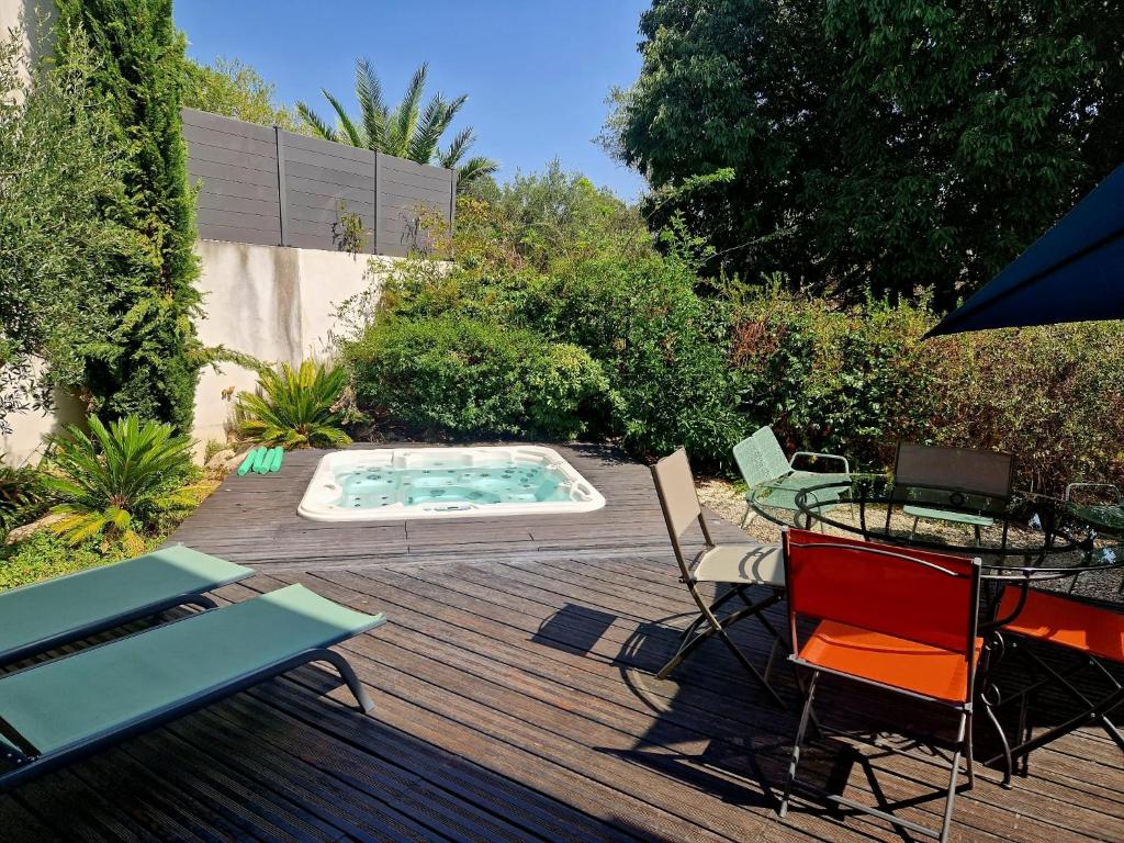 a backyard with a pool and a table and chairs at Villa Cosy T5, Calme avec Jacuzzi XL in Nîmes