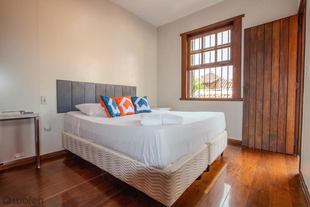 a large white bed in a room with a window at Hostel Wafeh Fleming in Belo Horizonte
