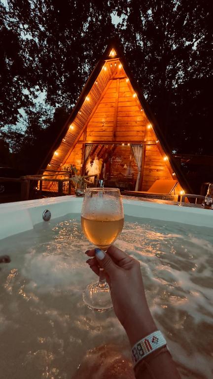 una persona sosteniendo una copa de vino en un jacuzzi en Valle Verde Eco, en Riofrío
