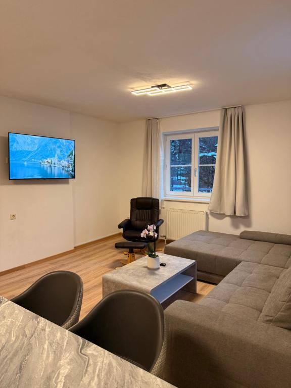una sala de estar con un sofá y una silla en Appartement Kodra, en Sonnberg