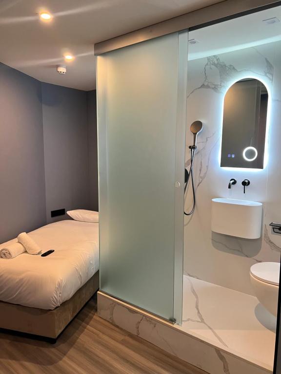 a bedroom with a bed and a sink and a mirror at The Hyve Budget Hotel Rotterdam in Rotterdam