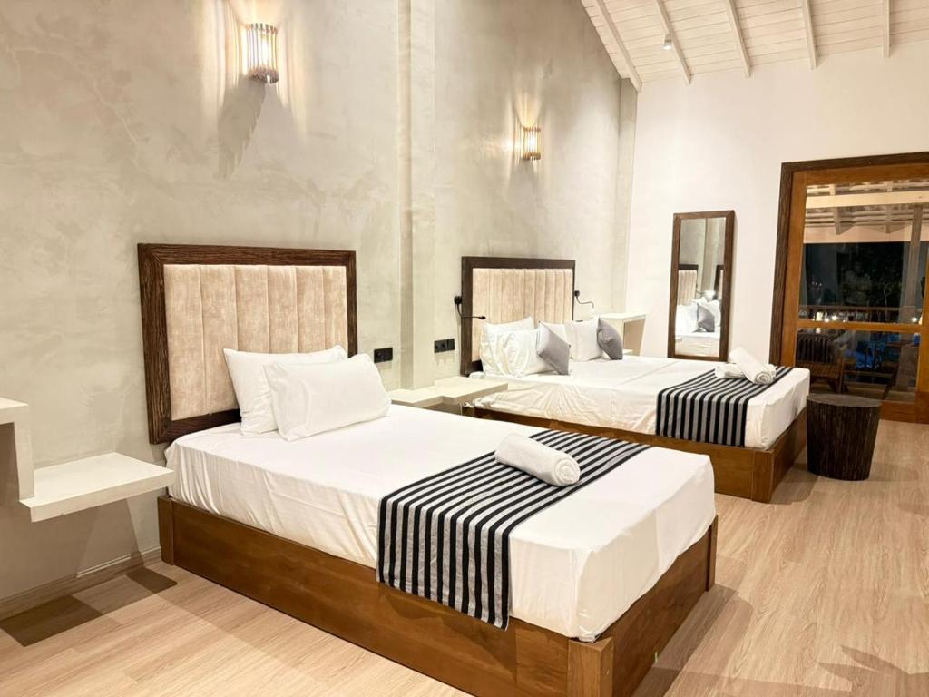 two beds in a hotel room with two bedsvisor at The Lavish Haven in Piyadigama