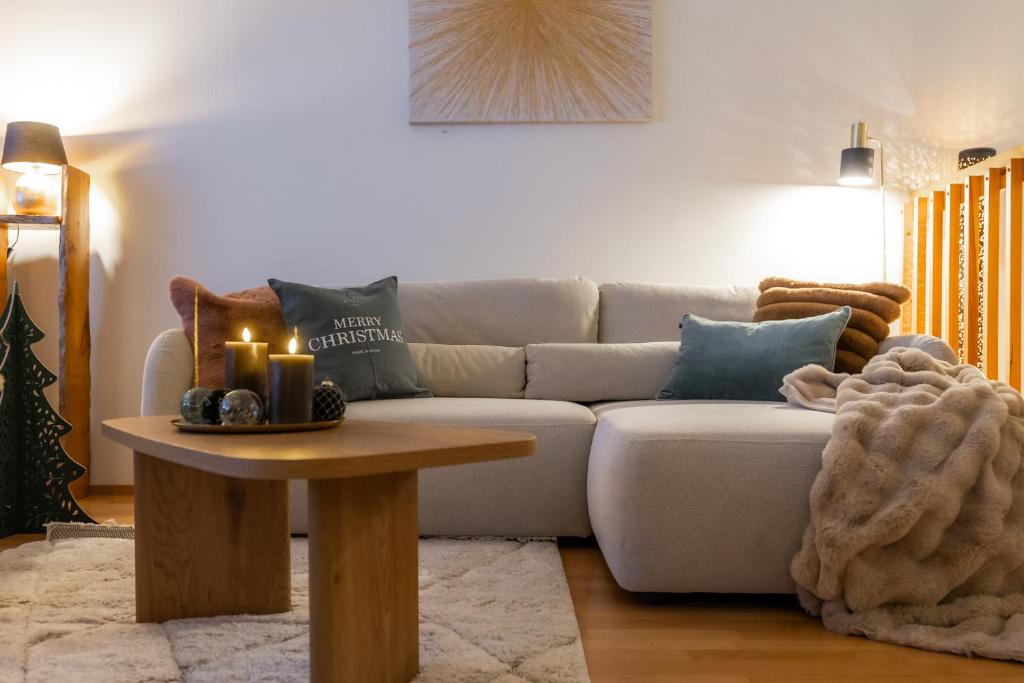 a living room with a couch and a table with candles at White Elegant Suite by the River in Rovaniemi
