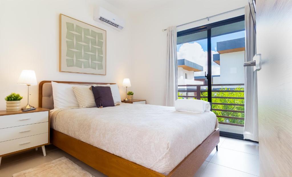 een slaapkamer met een bed en een groot raam bij Villa Castillo in Higuey