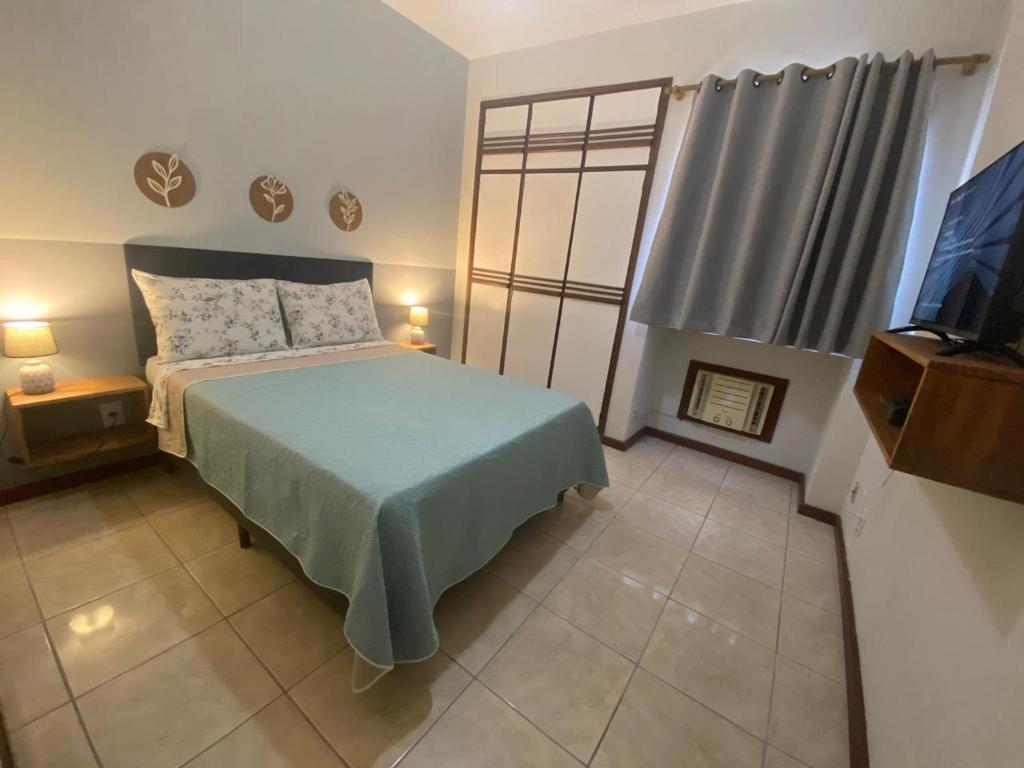 AP bem localizado na Praia do Canto في فيتوريا: غرفة نوم بها سرير وتلفزيون