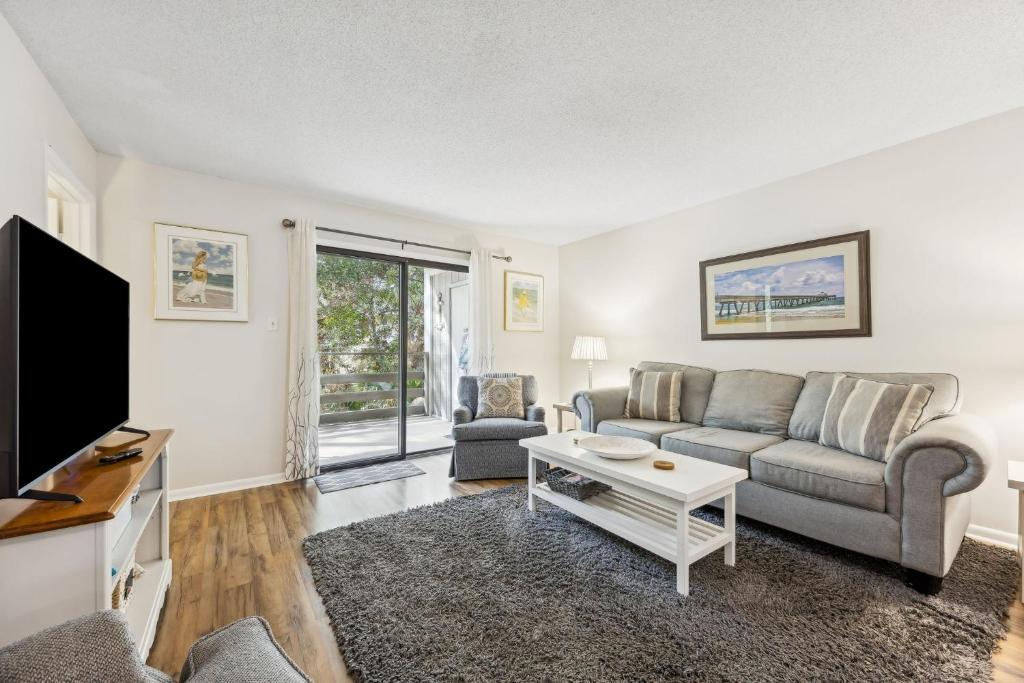 a living room with a couch and a tv at 3C Amelia Landings Condo in Fernandina Beach