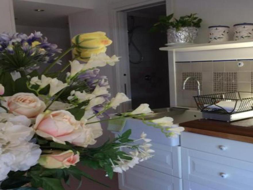 a vase of flowers on a counter in a kitchen at La Roseraie in Battipaglia