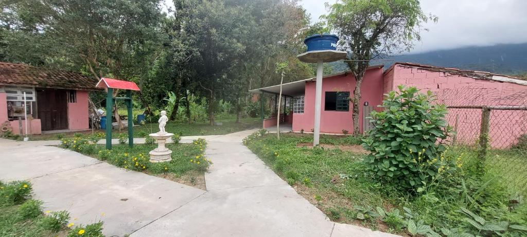 Hostel33 brazil praia في كاراغواتاتوبا: مبنى وردي اللون عليه عمود لتغذية الطيور