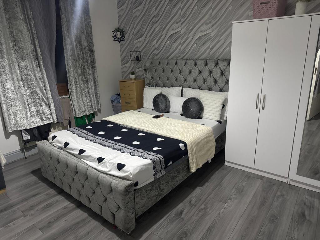 1 dormitorio con 1 cama grande y armario blanco en Guest Home, en Birmingham