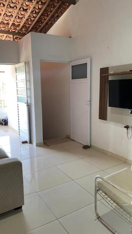 a white room with a door and a tv at Casa em Porto de pedras in Tatuamunha