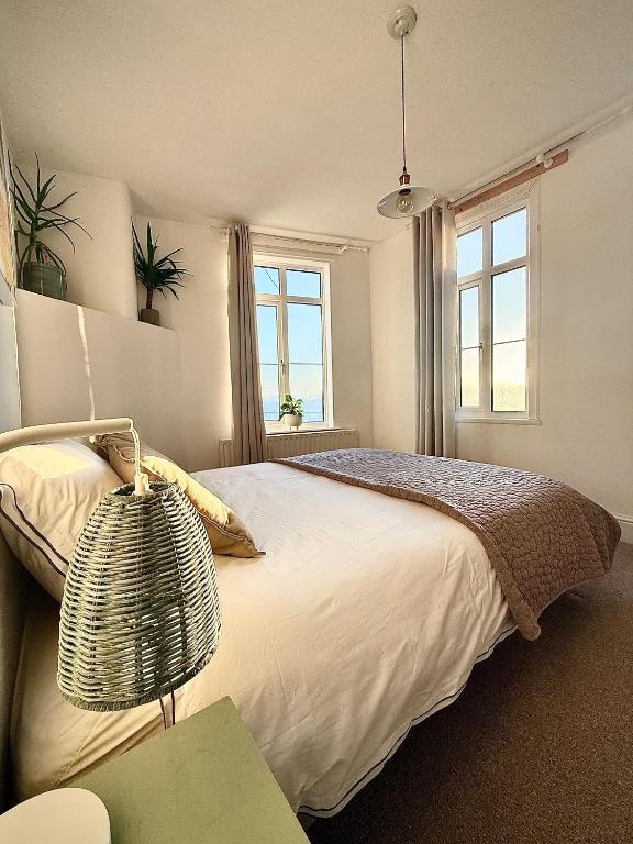 a bedroom with a large bed and two windows at Henwick Loft in Henwick