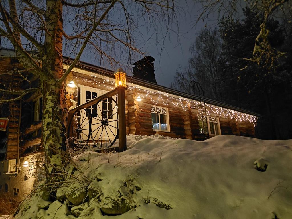 a house with christmas lights on it in the snow at A room (or 2 or 3) in a Lapland House of Dreams in Rovaniemi