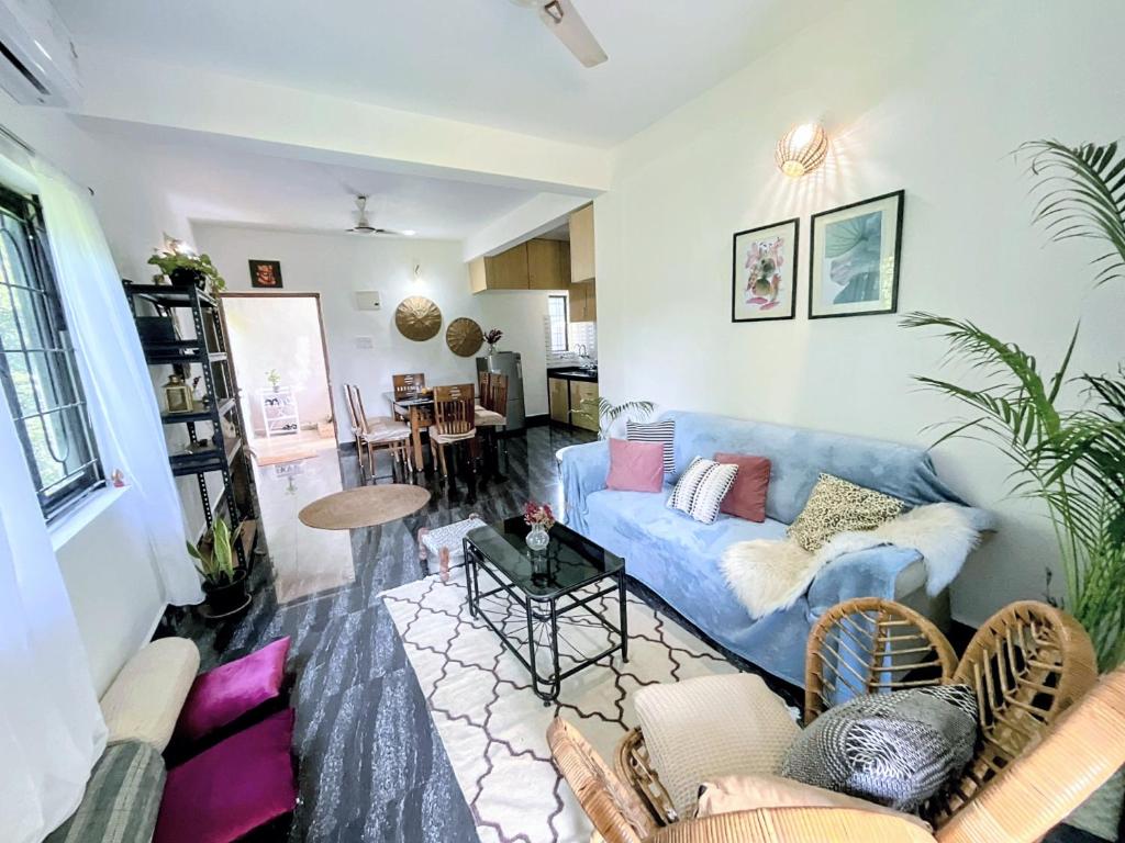 a living room with a blue couch and a table at Casa Palolem in Canacona