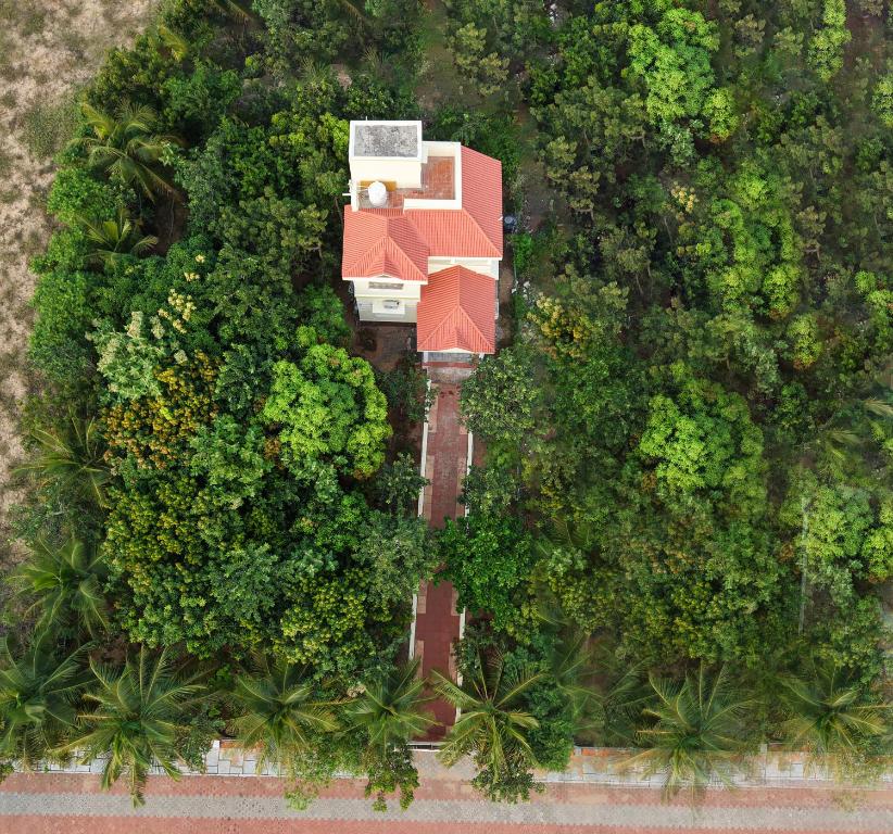 Una vista aérea de una casa en medio de árboles. en Neithal Illam, en Cheyūr