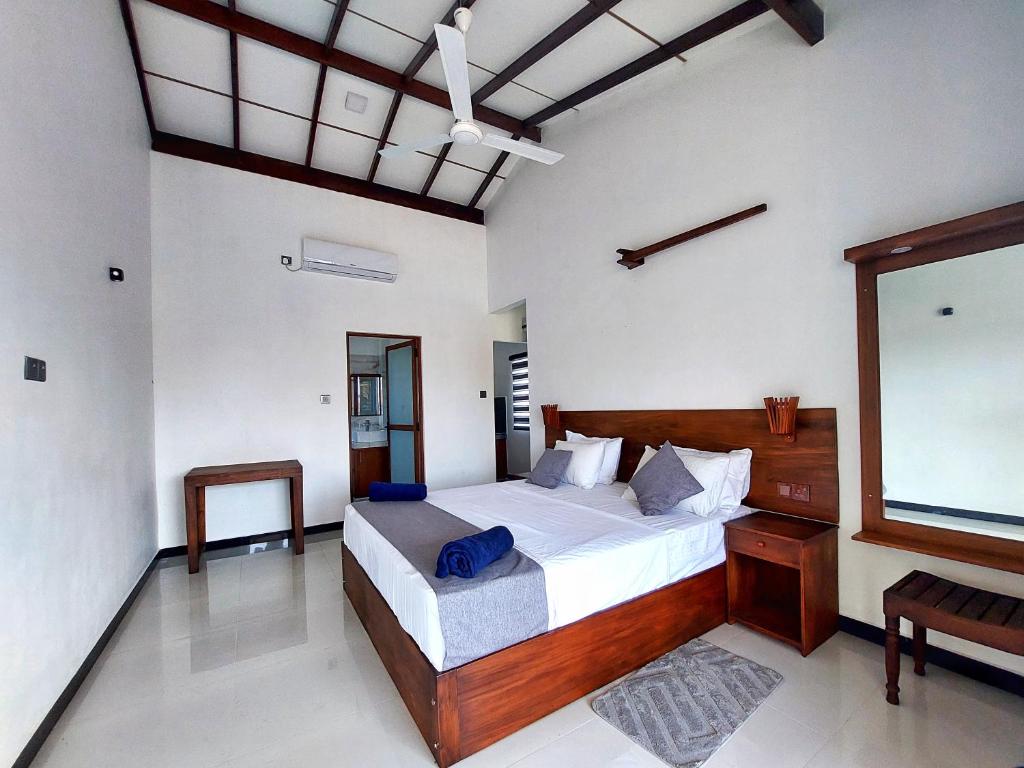 Sweden Inn Guesthouse في هيكادوا: غرفة نوم بسرير كبير ونافذة