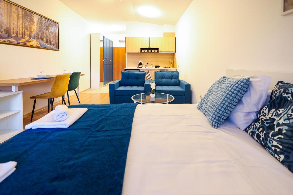 a bedroom with a large bed and a living room at Blue Nest Studio - Free Parking and Mountain View in Razlog