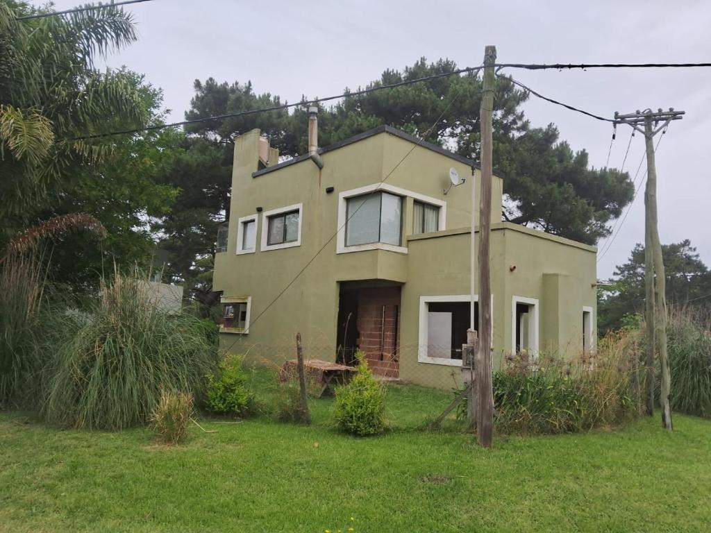 ein altes gelbes Haus auf einem Grasfeld in der Unterkunft Casa en La Caleta Mar de Cobos in Mar de Cobo