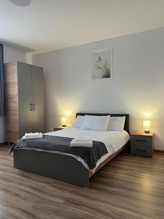 Un dormitorio con una cama grande con dos lámparas encima. en Salin Home, en Ocna-Mureşului