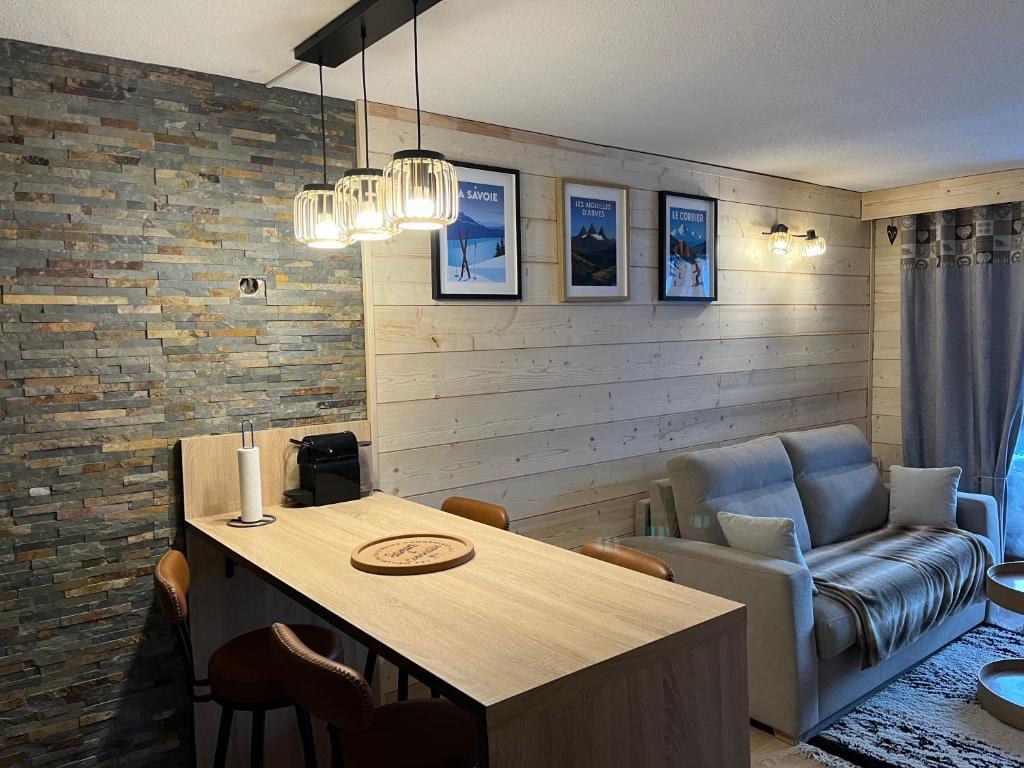 LE CORBIER Vue pistes Studio 5 personnes entièrement rénové في Villarembert: غرفة معيشة بها طاولة وأريكة