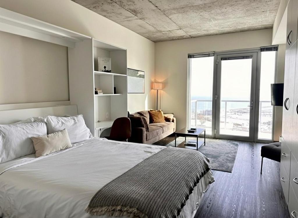 una camera da letto con un letto e un soggiorno con un divano di Luxury Penthouse Apt Near Brady St with Balcony and Lake View a Milwaukee