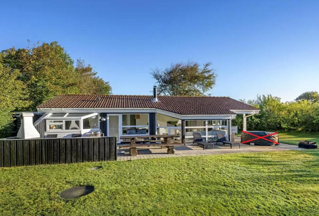 a house with a picnic table in a yard at Fjordferie Hemmet Strand in Hemmet