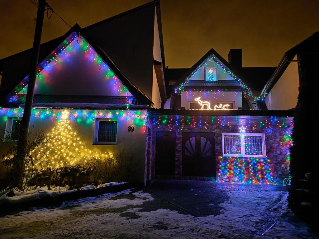a house covered in christmas lights in a yard at Biesiada in Czarna Góra