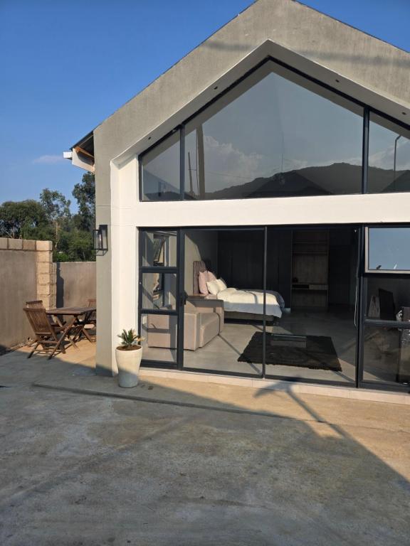 eine Glaserweiterung eines Hauses mit einem Wohnzimmer in der Unterkunft iThusi stream in Mbabane