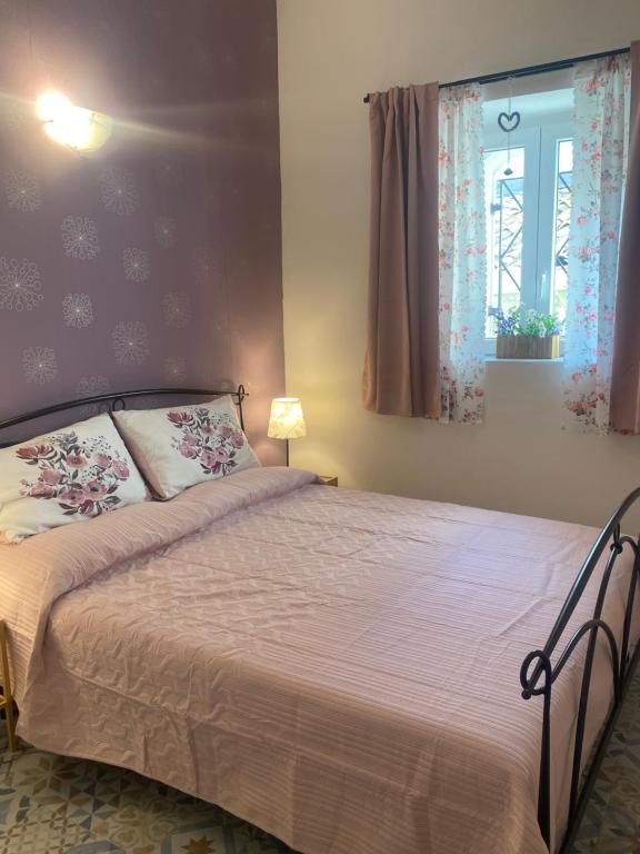 een slaapkamer met een bed en een raam bij Laura's Cottage in Calatabiano