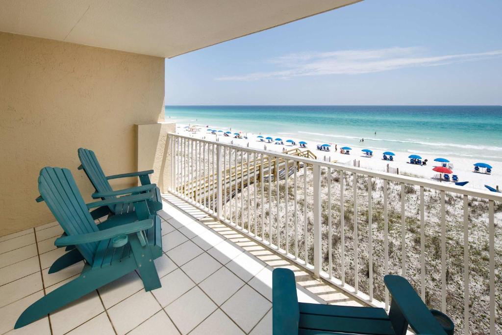a balcony with two chairs and the beach at Gulf Side 402 Pet friendly gulf front condo in Fort Walton Beach