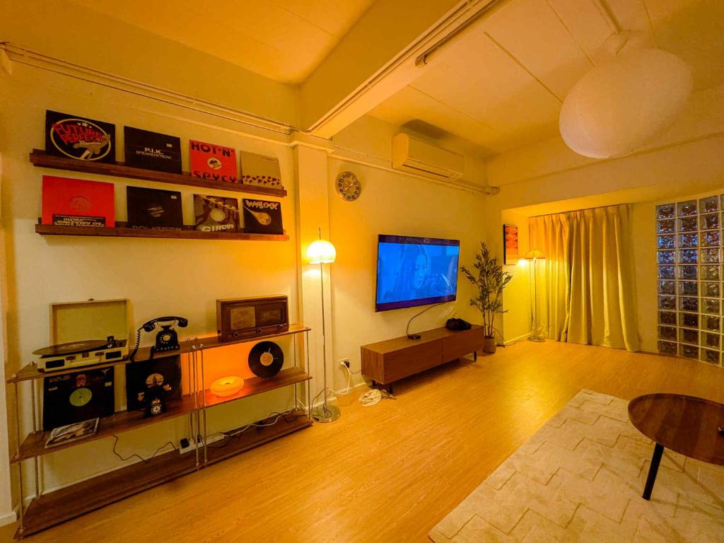 een woonkamer met een televisie en een tafel bij Florent House in Chiang Mai