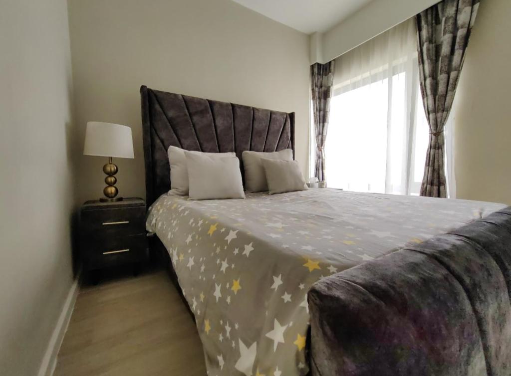Un dormitorio con una cama grande con una ventana grande. en Riverside Square, en Nairobi