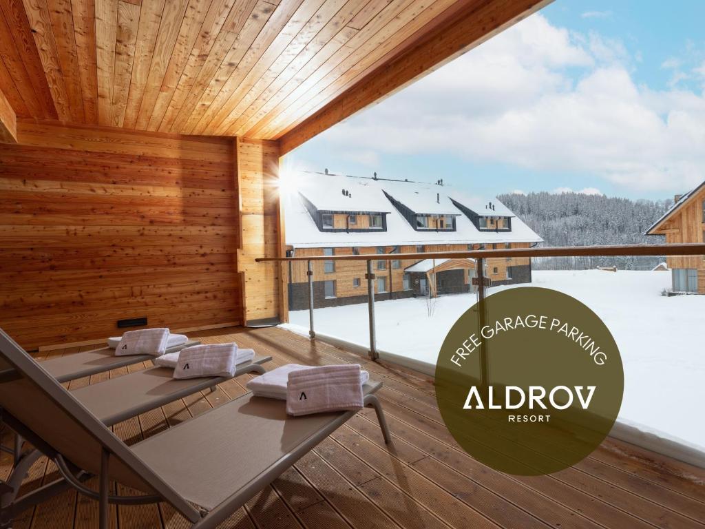 a dining room with a large window with snow on the ground at Aldrov Resort in Vítkovice